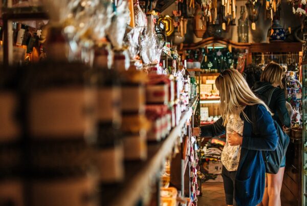 Commerçante arrangeant des produits dans une boutique — formations pour commerçants chez Annexe Codex